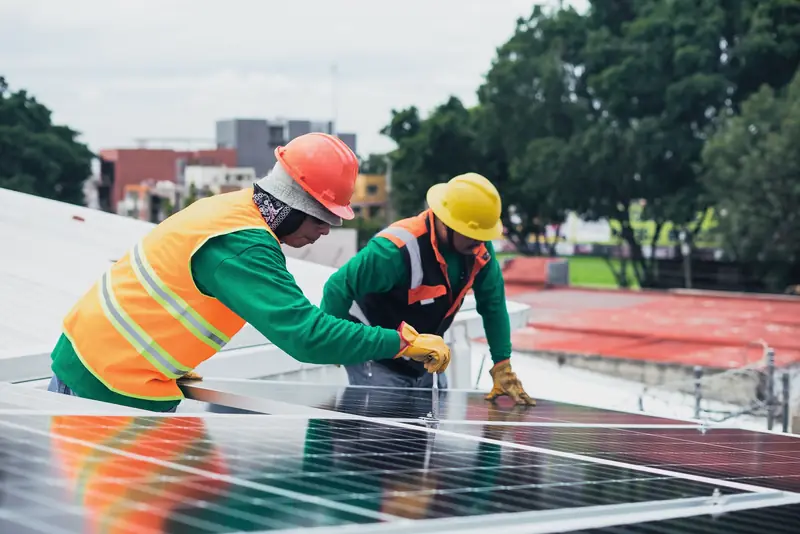 Tecnici installano moduli fotovoltaici su una copertura piana